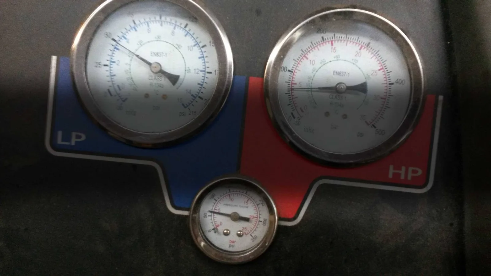 Manometer eines Klimaservicegeräts mit blauer und roter Anzeige