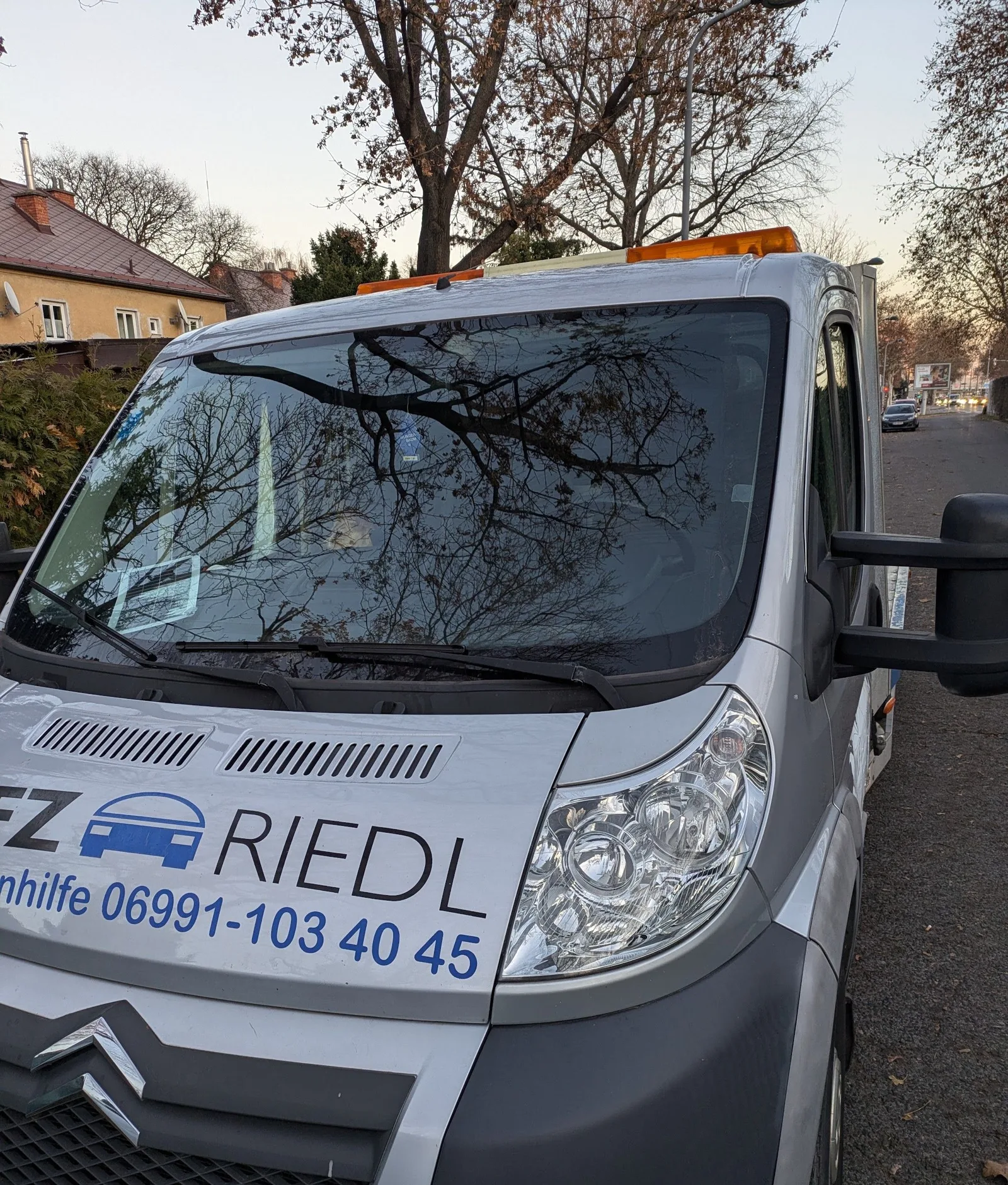 Abschleppfahrzeug mit dem Logo KFZ RIEDL und der Aufschrift Pannenhilfe